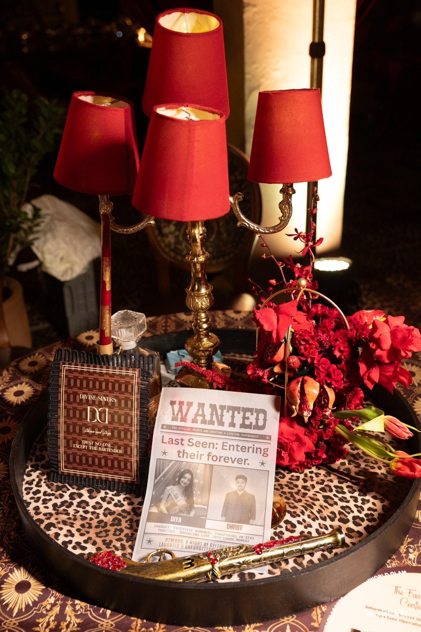 Divine Sinners styled table with red lamps, flowers and Wanted card detail