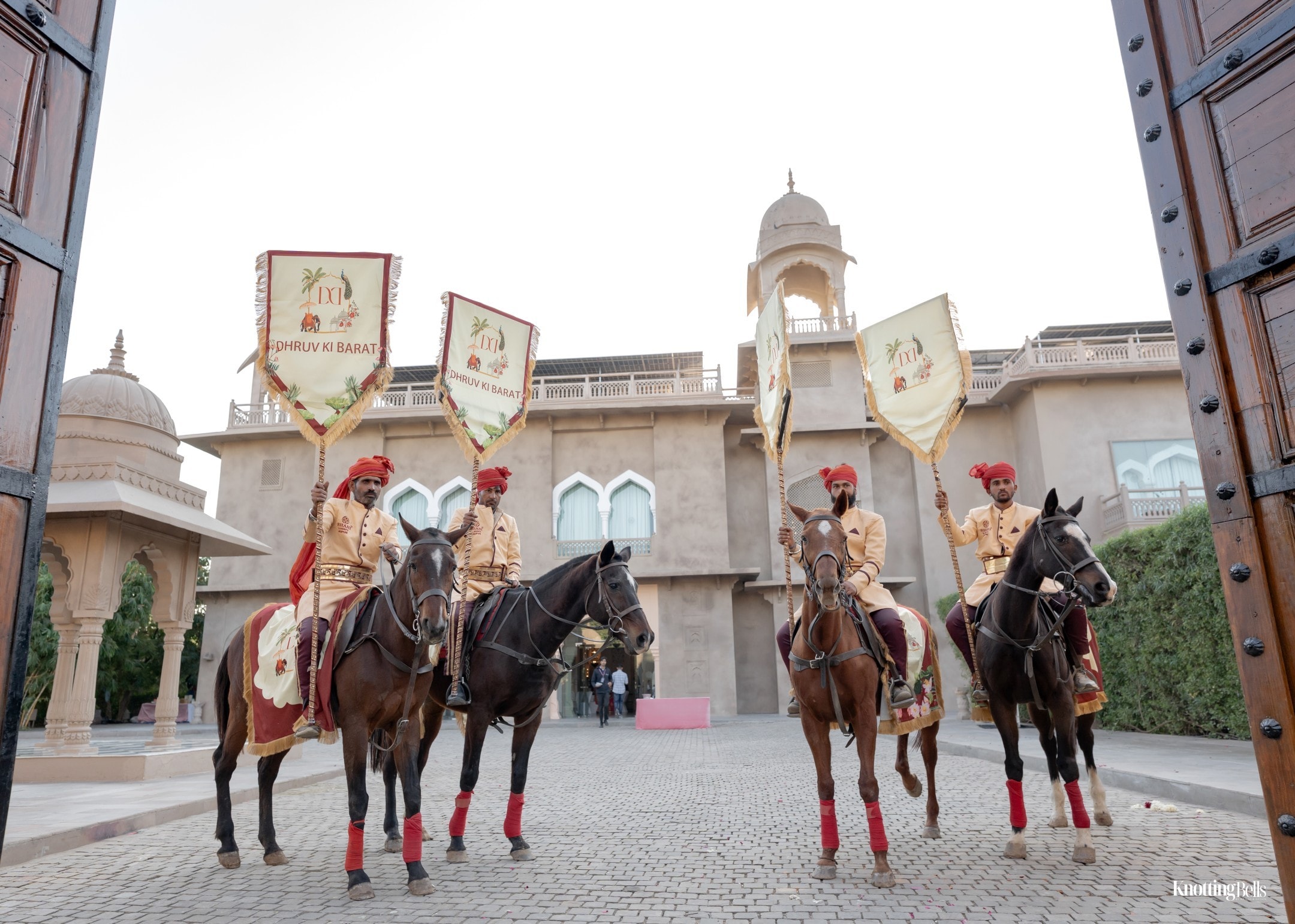Dhruv Ki Baraat — four mounted guards with royal banners at palace gates